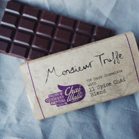 Chai Walli Chai Chocolate bar with its cover on the side on a grey tablecloth